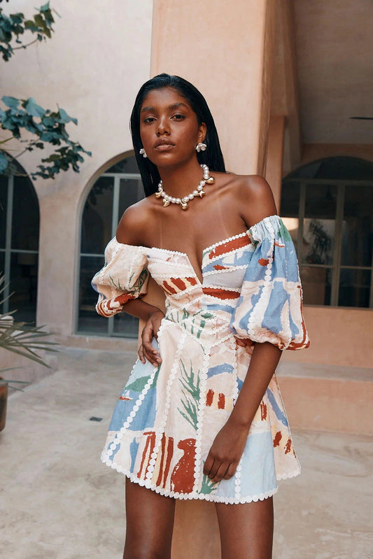 Boho Chic Mini Dress: Off-Shoulder, Tribal Print, Pom-Pom Trim
 - ModishWorld